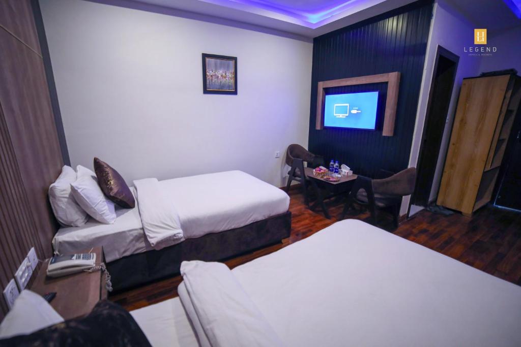 a hotel room with two beds and a tv at Legend Hotel Skardu in Skardu