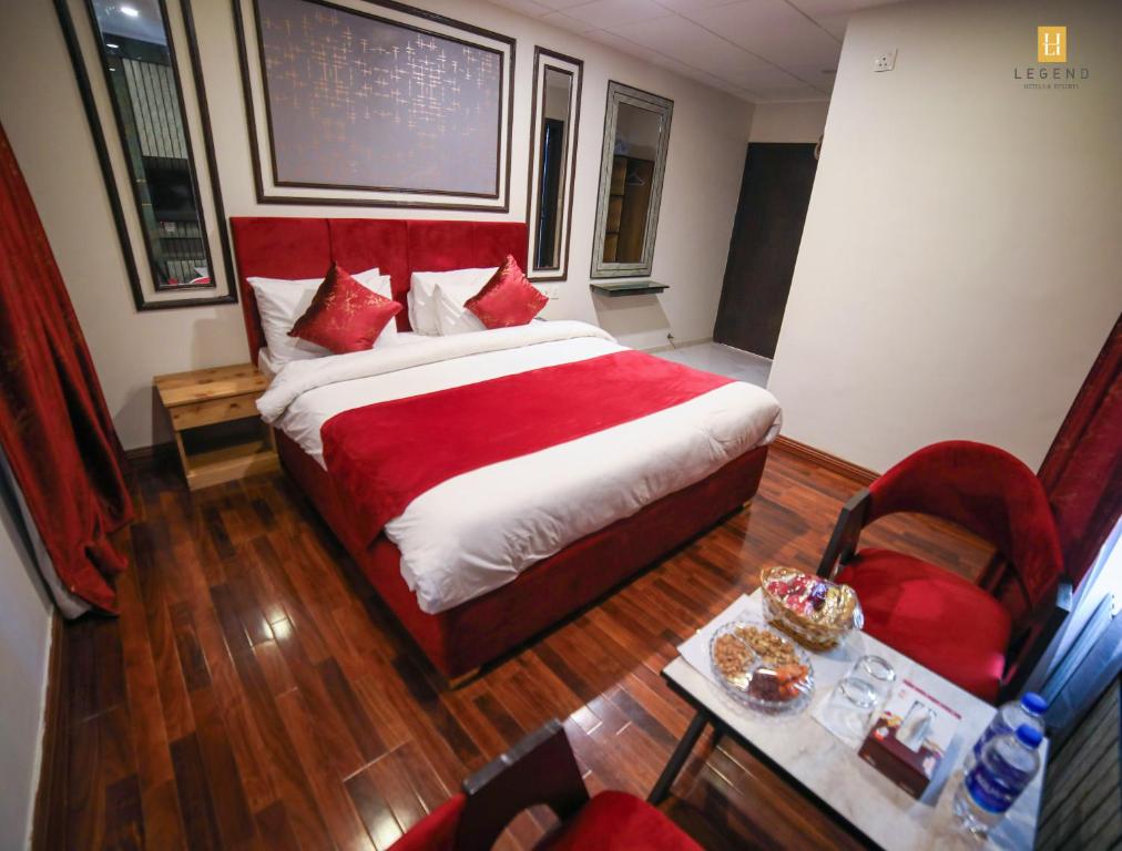 a bedroom with a large bed and a table and a chair at Legend Hotel Skardu in Skardu