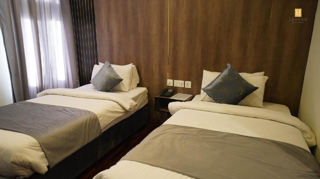 a hotel room with two beds and a window at Legend Hotel Skardu in Skardu