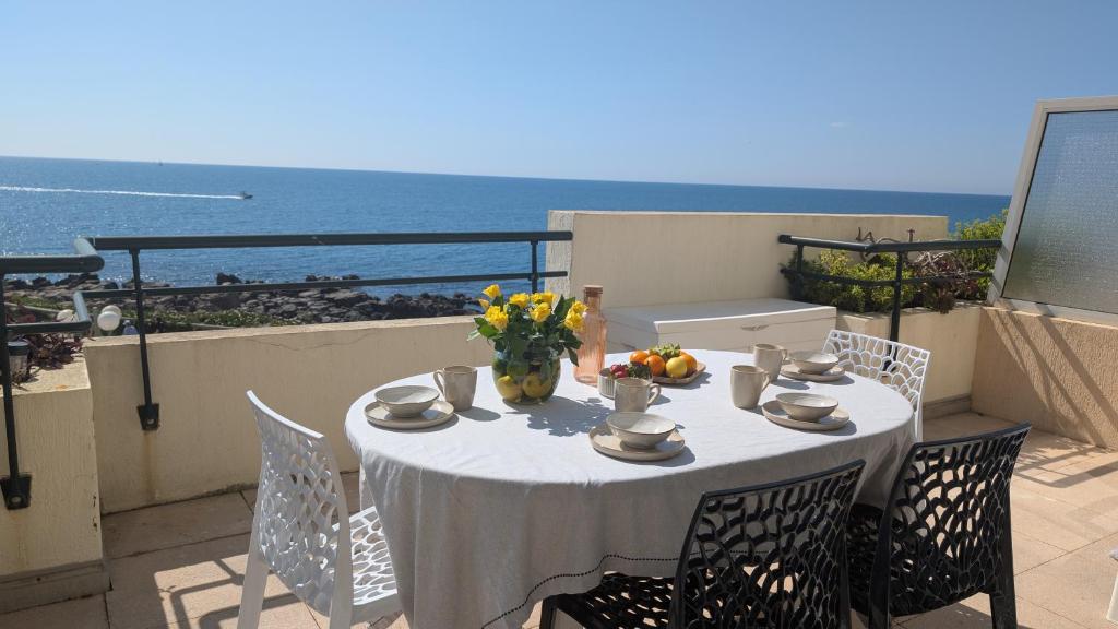 une table avec un vase de fleurs sur un balcon dans l'établissement T3 refait à neuf vue mer, piscine, clim, garage, wifi, à Sète