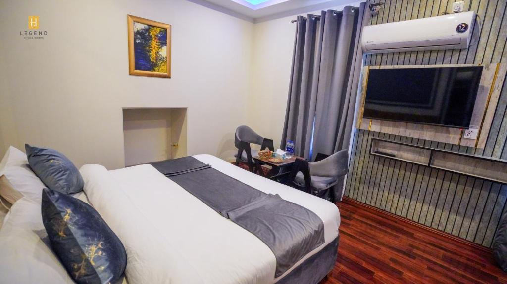 a hotel room with a bed and a flat screen tv at Legend Hotel Skardu in Skardu