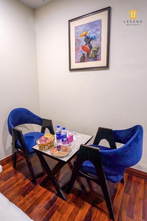 a table with two chairs and a table with food on it at Legend Hotel Skardu in Skardu