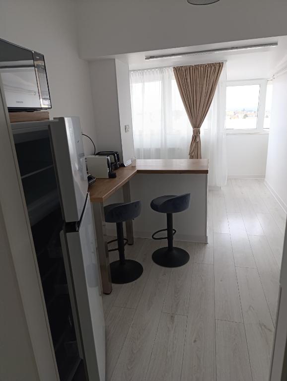 a kitchen with two bar stools and a counter top at Central I in Târgu Jiu