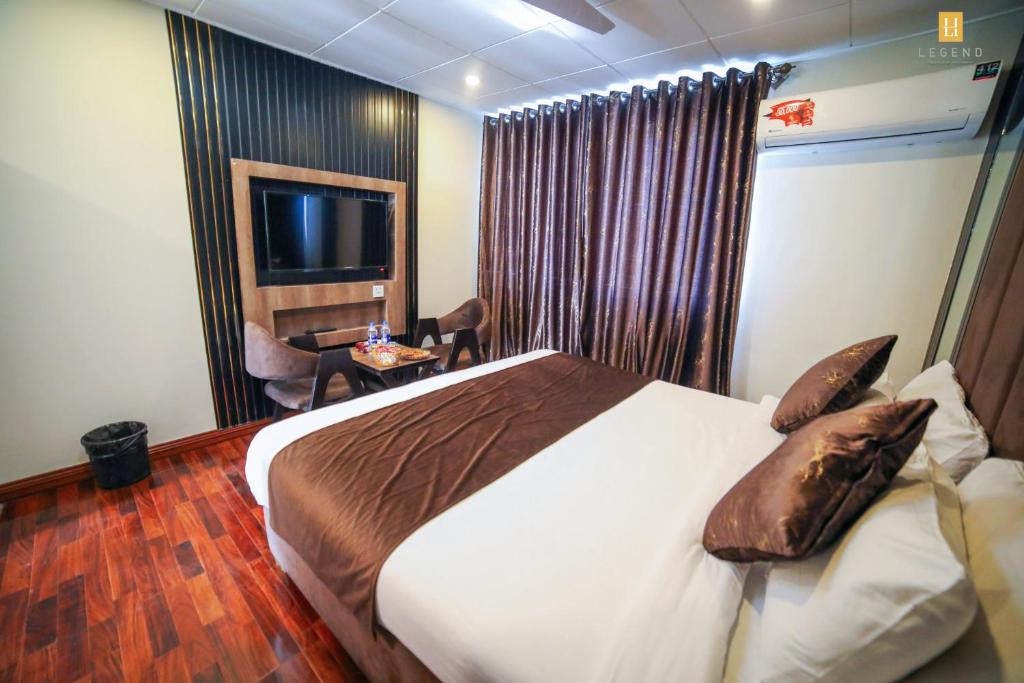 a hotel room with a large bed and a chair at Legend Hotel Skardu in Skardu