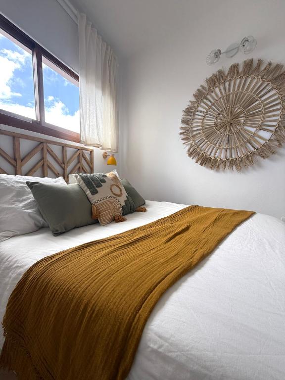 a bedroom with a bed with a gold blanket on it at Vv Estudio88 in Valverde