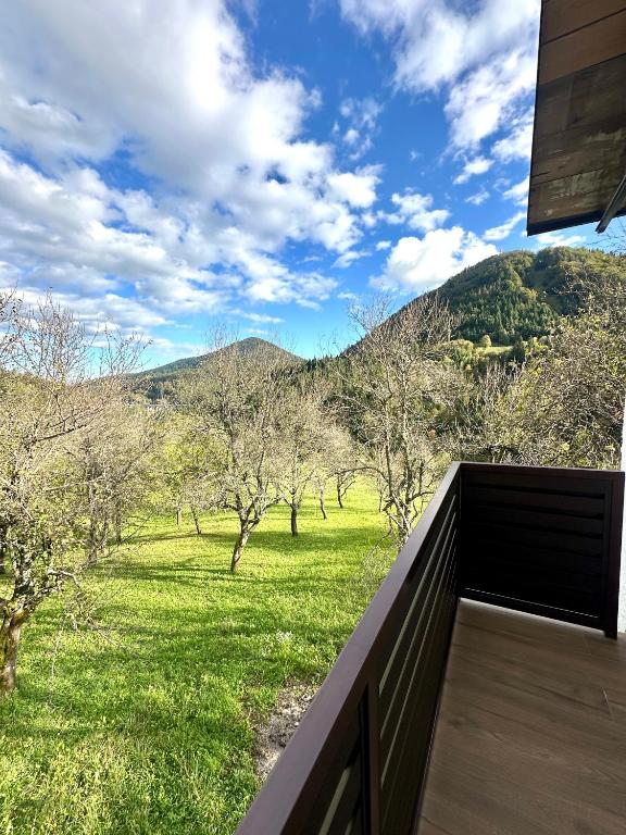 a balcony with a view of a field and trees at Apartman Bajt in Ravna Gora