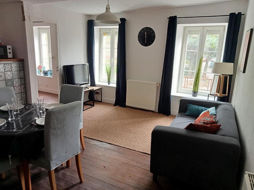un salon avec un canapé et une table dans l'établissement Close to Beaches and Bayeux, à Tour-en-Bessin