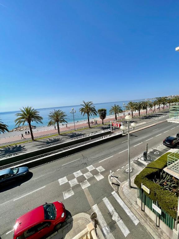 une route avec des voitures garées au bord de la plage dans l'établissement Promenade des Anglais panoramic sea view, à Nice