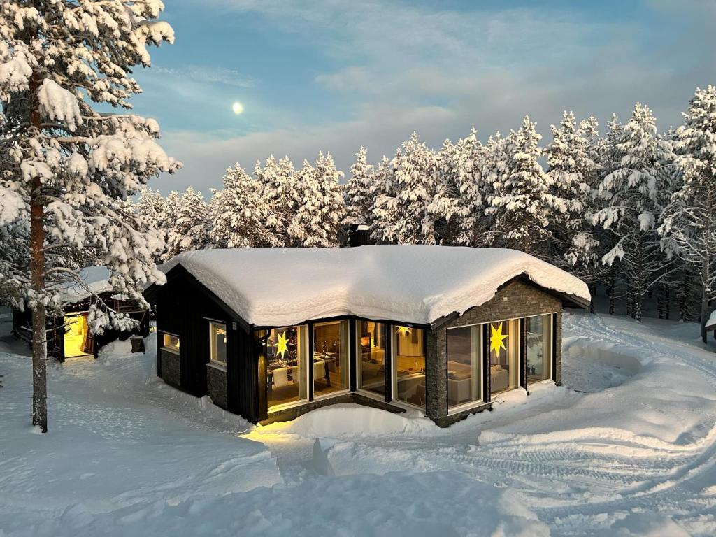 una cabina nella neve con alberi innevati di Neiden hytten a Neiden