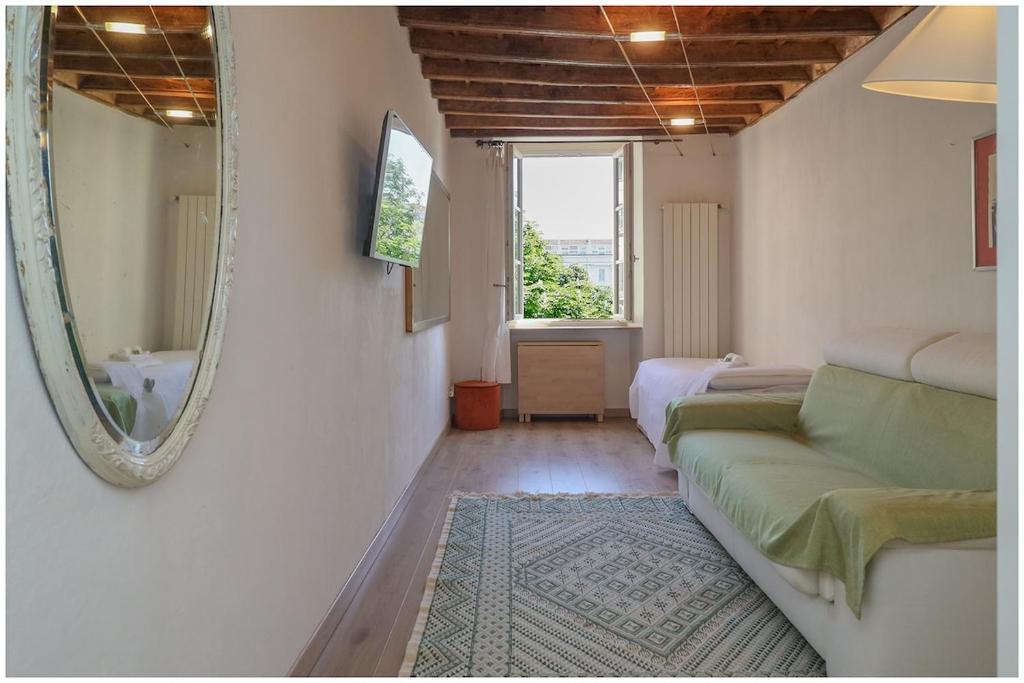 a living room with a couch and a mirror at Carlina Charme 10 minutes from Porta Nuova - WIFI in Turin