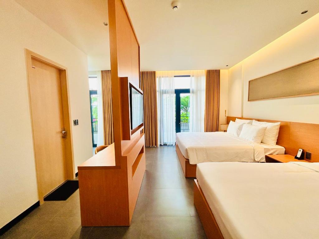 ein Hotelzimmer mit zwei Betten und einem Fenster in der Unterkunft Thai Hoang Villa Quảng Bình in Dong Hoi