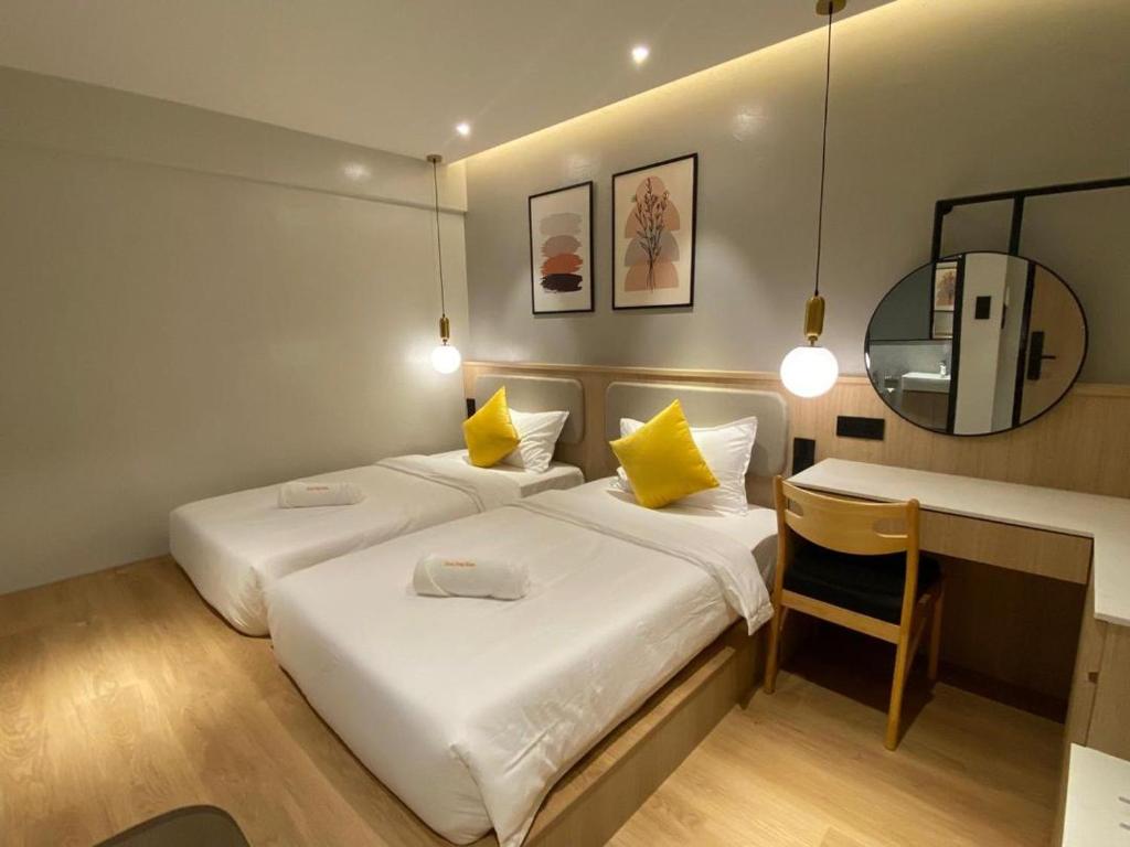 a bedroom with two beds and a desk and a mirror at 32D Home Sleep Home in Kuah