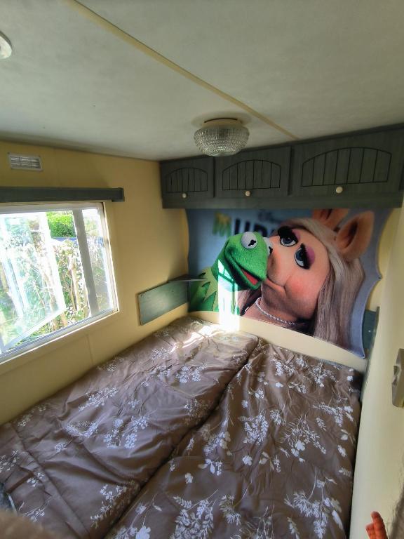une chambre avec un lit avec une peinture d'un poney dans l'établissement Mobil home Kermit côté atantique royan 17 camping 3 étoiles, à Breuillet