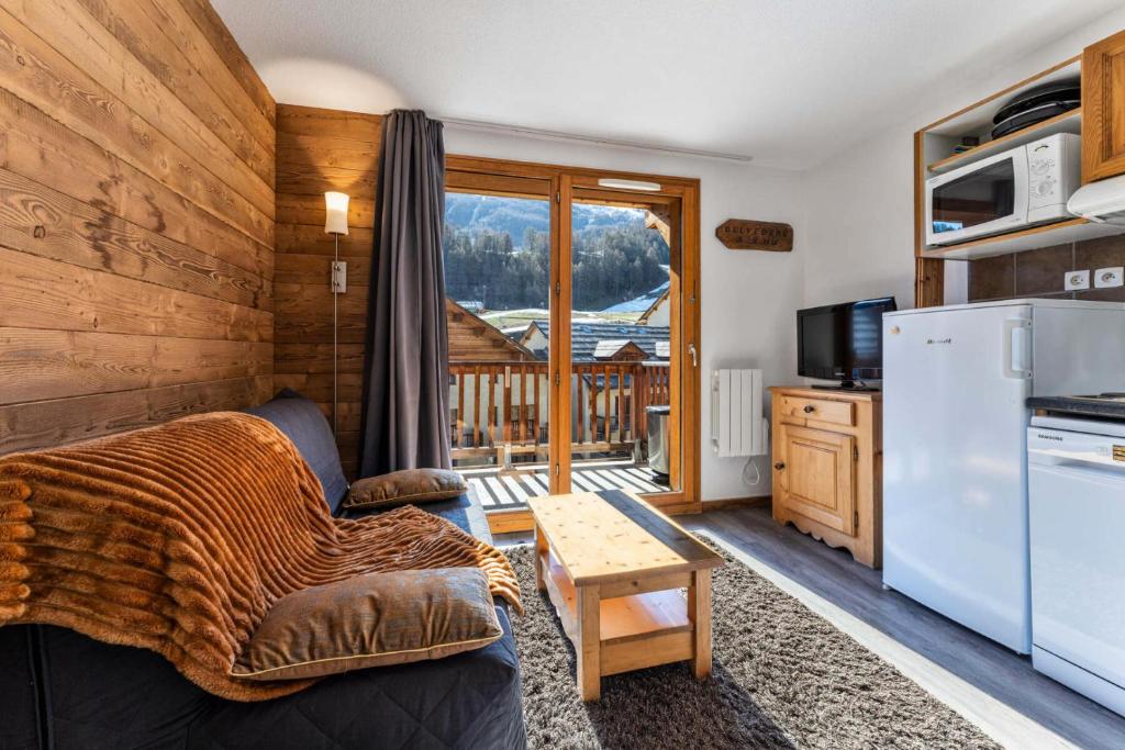 - un salon avec un canapé et un réfrigérateur dans l'établissement Les Chalets De Bois MÉan - A - Chaleureux duplex pour 6 personnes aux Orres 1800 MAE-4581, aux Orres