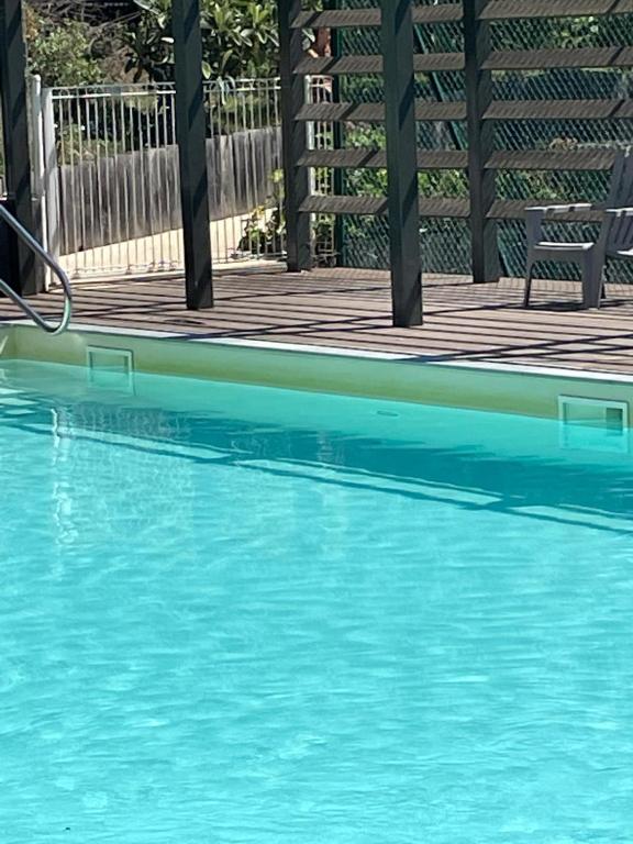 une piscine d'eau bleue à côté d'une terrasse en bois dans l'établissement Cœur du vieux Lyon et zone de loisir, à Lyon