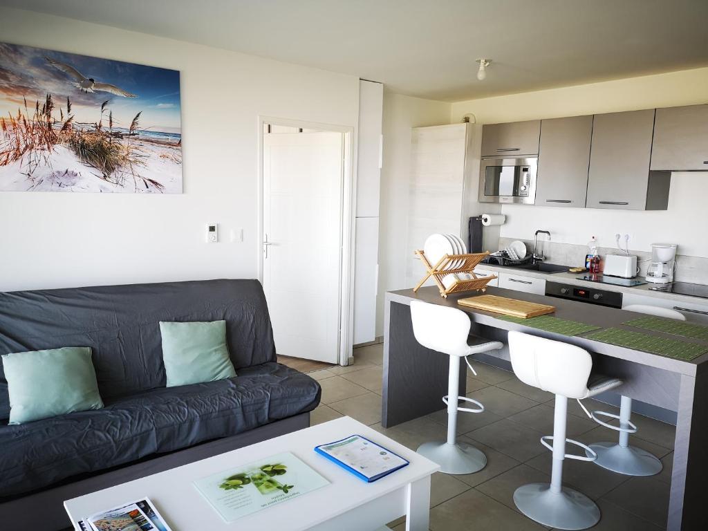 un salon avec un canapé et une cuisine dans l'établissement Apartment with sea views, à Berck-sur-Mer