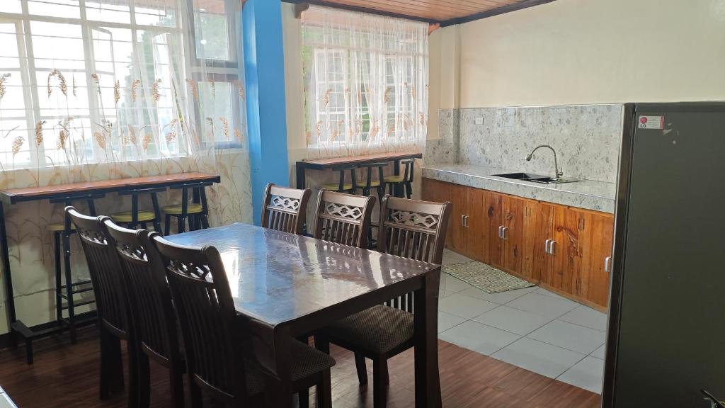a kitchen with a dining room table and chairs at KBC ZAI Baguio Staycation 1 in Baguio