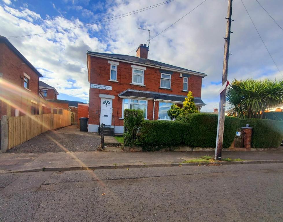 a brick house with a white door on a street at Entire House in Belfast