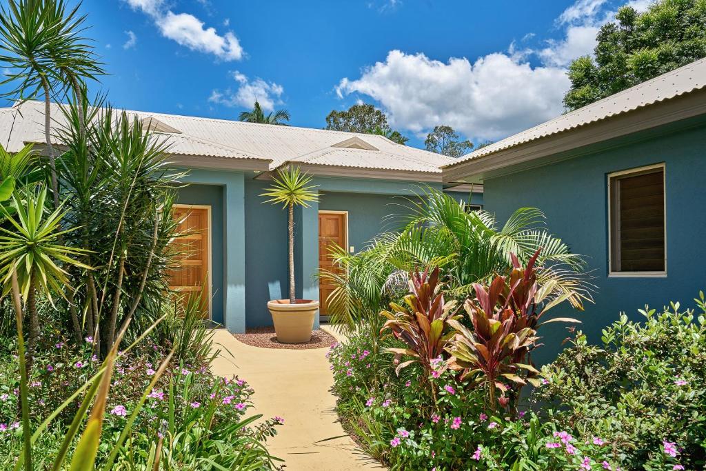 a blue house with plants in front of it at Blue Summit Hideaway in Yungaburra