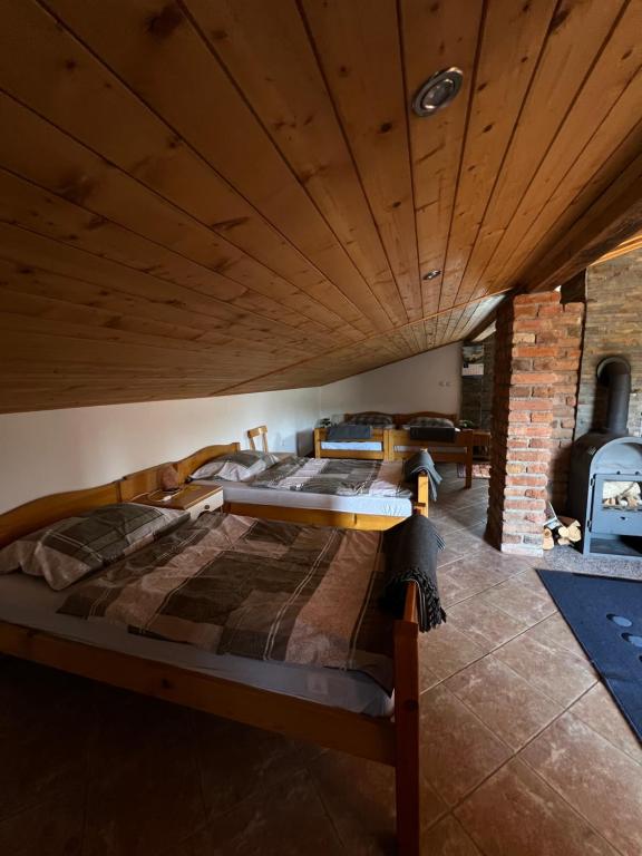 sypialnia z dużym łóżkiem i drewnianym sufitem w obiekcie Hacienda in pure nature w mieście Ožegovci