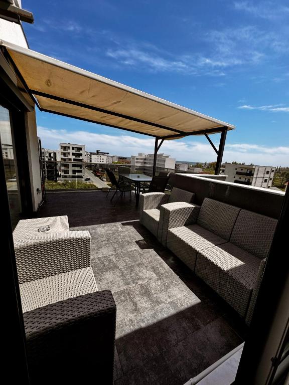 a patio with two couches and a table on a roof at RoApart B2 Home Apartamente 2 și 3 camere terase spațioase vedere si parcare in Năvodari