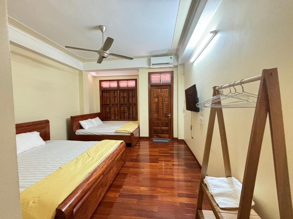 een slaapkamer met twee bedden en een plafondventilator bij Phương Huyền Beauty in Diện Biên Phủ
