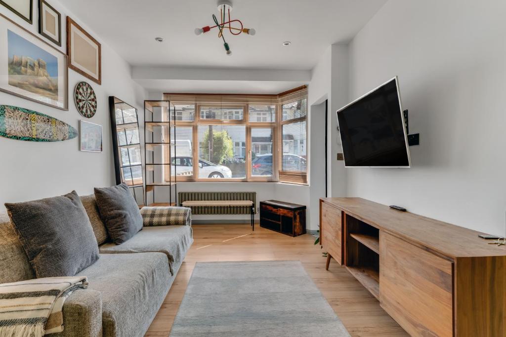 Hanwellにある2BR Garden Home Free Parking for 7 Guests Easy Access to London & Heathrowのソファと薄型テレビのあるリビングルーム