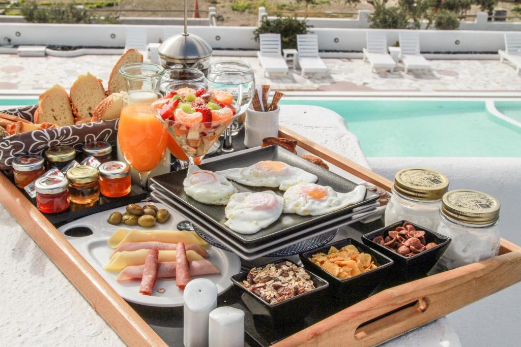 a tray of food on a table next to a pool at The Fisherman's House Santorini in Akrotiri