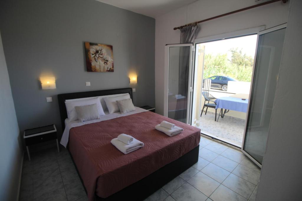a bedroom with a bed with two towels on it at Tony's Apartments in Agios Georgios