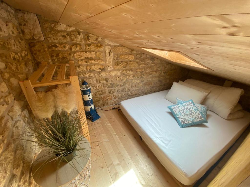 a bed in a small room in a tiny house at Maison de charme à 300m de la plage in Saint-Pierre-dʼOléron