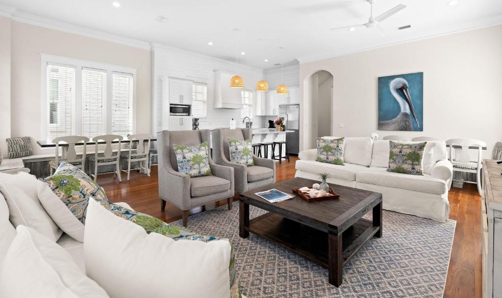 a living room with white furniture and a table at Inlet Breeze in Inlet Beach