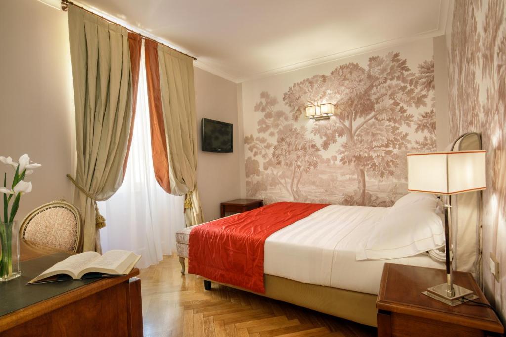 sypialnia z łóżkiem i biurkiem z lampką w obiekcie Vivaldi Luxury Rooms w Rzymie