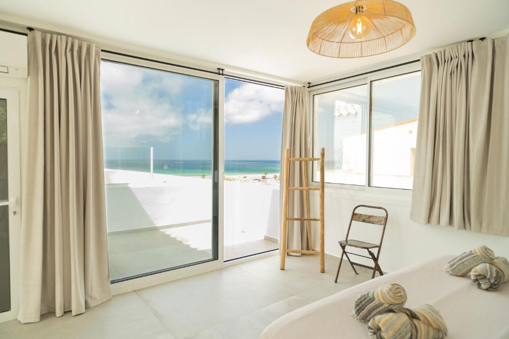 sypialnia z łóżkiem i widokiem na plażę w obiekcie Tarifa Cozy House - Minimaliste w mieście Tarifa