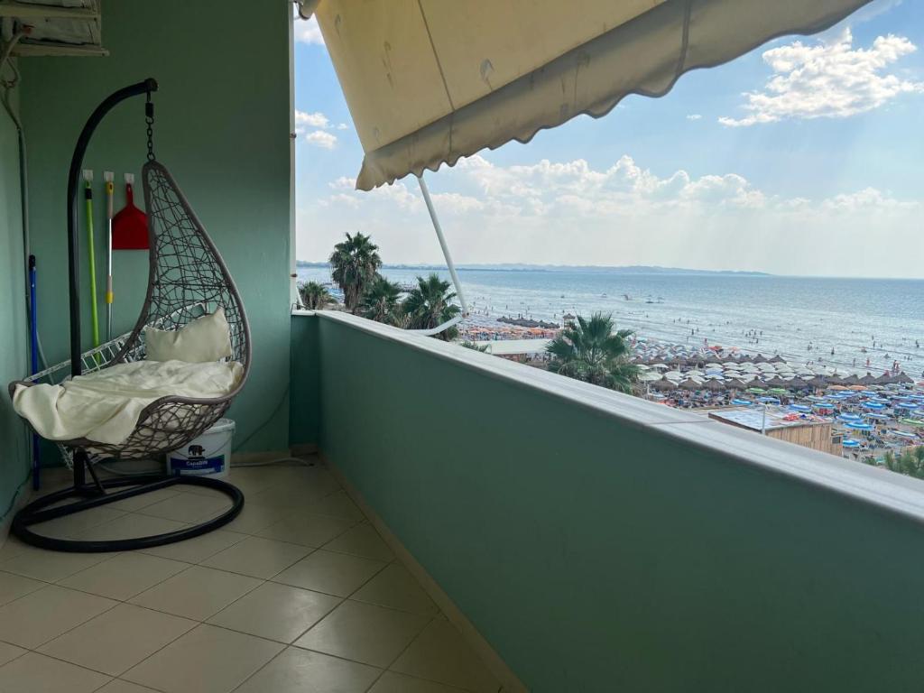 a balcony with a chair and a view of the beach at Sea view in Durrës