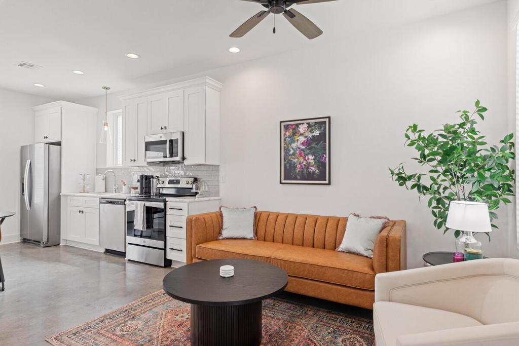Una sala de estar con un sofá y una cocina. en NEW Couyon House Luxury Amenities Fast WiFi 65 TV, en Lafayette