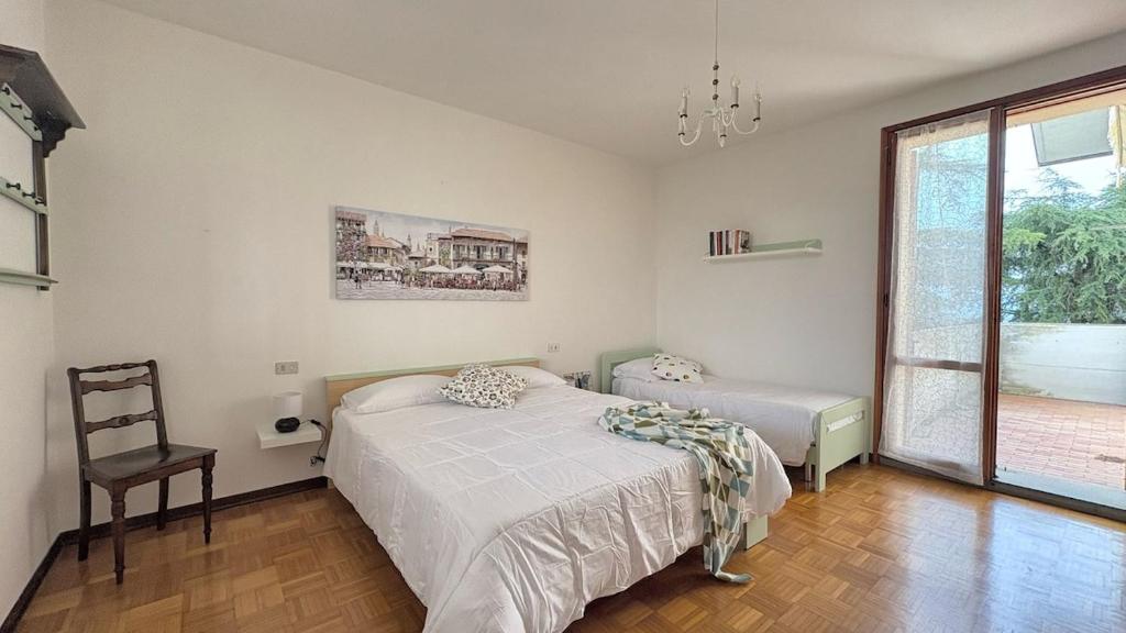 Un dormitorio con una cama y una silla y una ventana. en Il Sassolino holidays apartment, en Ripe