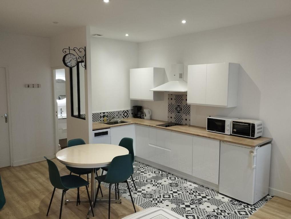 - une cuisine avec une table, une table et des chaises dans l'établissement Studio Proche Cure Rochefort, à Rochefort