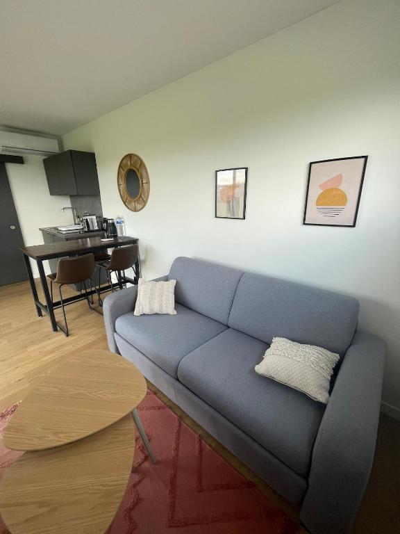 un salon avec un canapé bleu et une table dans l'établissement Studio de jardin neuf, à Étoile-sur-Rhône
