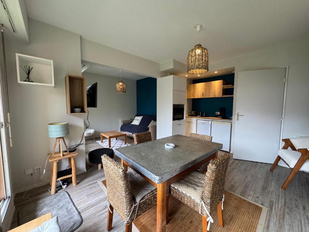 un salon avec une table et des chaises de salle à manger dans l'établissement Les Mules - Wifi, Parking, Piscine, Central, à La Baule