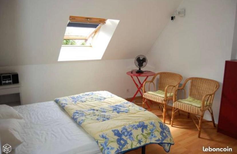 une chambre avec un lit et deux chaises et une fenêtre dans l'établissement Maison de vacances, à Montoire-sur-le-Loir