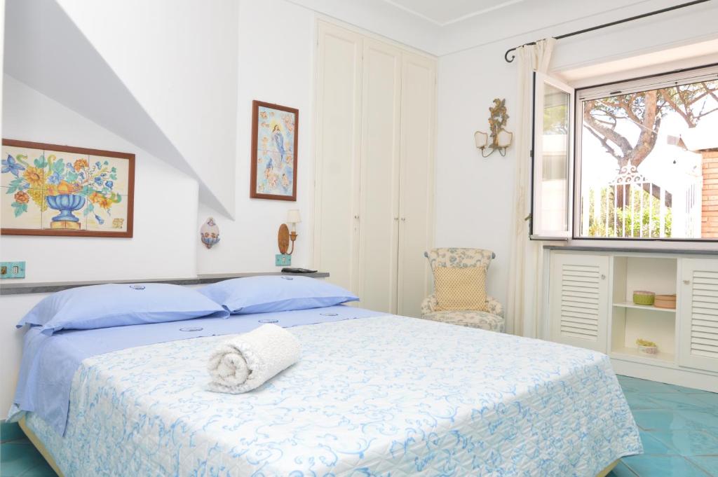 ein weißes Schlafzimmer mit einem Bett und einem Fenster in der Unterkunft AUGUSTUS PARK Capri Center in Capri