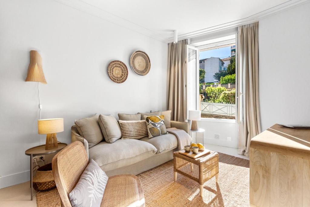 un salon avec un canapé et une fenêtre dans l'établissement 2BR Boutique-Apartment in Cannes, strand- und zentrumsnah 10-15 Minuten, à Cannes