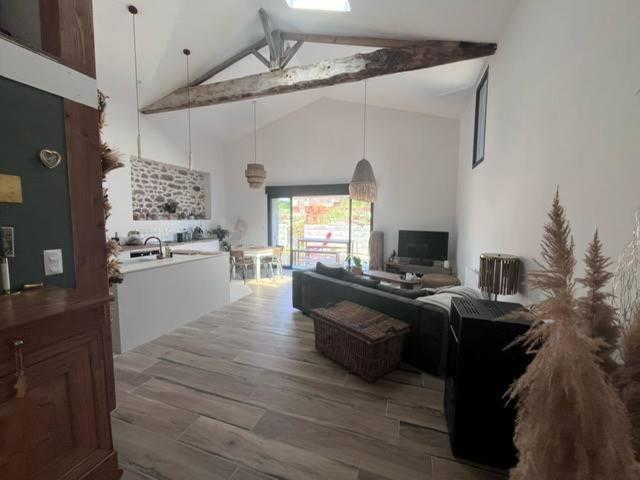 a living room with a couch and a kitchen at la maison de Mélissa in Gétigné