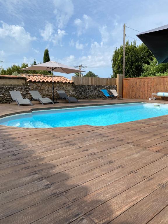 une piscine avec des chaises et un parasol dans l'établissement Villa de standing avec Piscine et Jacuzzi, à La Bruguière