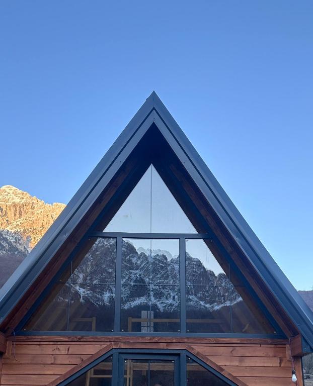 a window of a house with mountains in the background at SeSam Villas in Theth