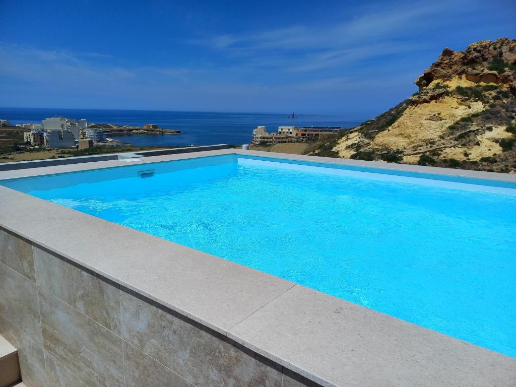 una piscina con vista sull'oceano di Yellow Hill Penthouse a Żebbuġ