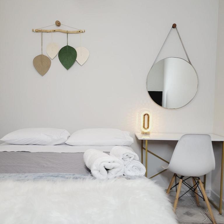 a bedroom with a bed with a mirror and a chair at Espaço IN 4 Quarto Brooklin in Sao Paulo