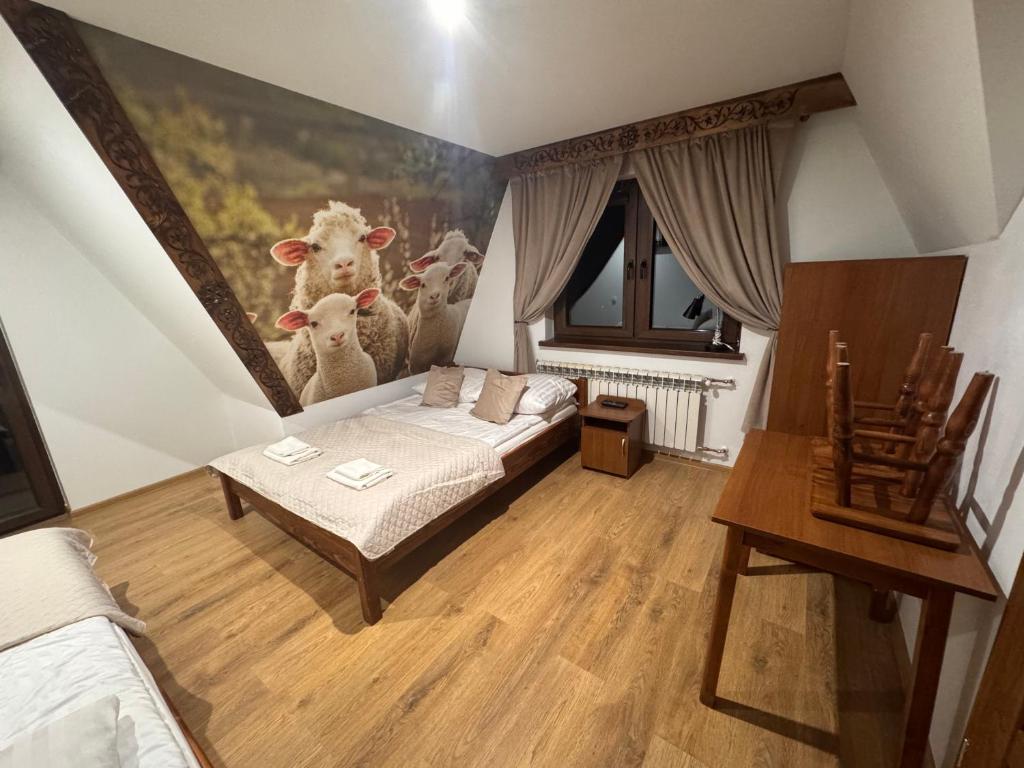 a bedroom with a bed and a painting of cows at Pensjonat U Zosi in Male Ciche