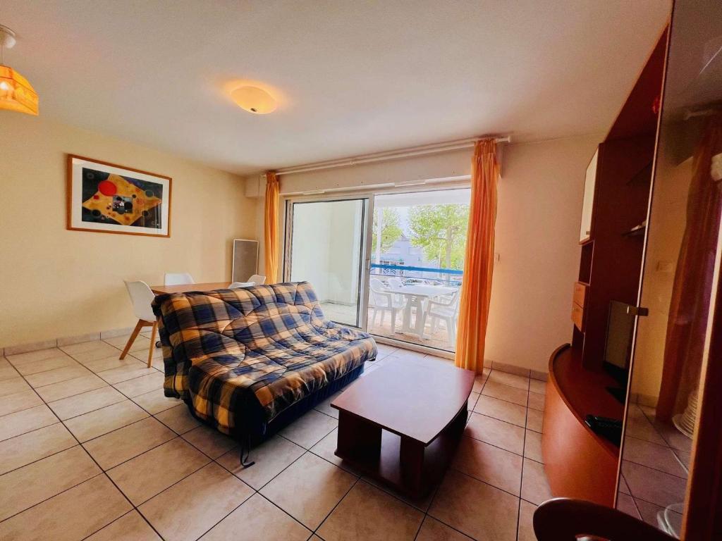 un salon avec un canapé et une grande fenêtre dans l'établissement 3 pièces à Quiberon - 48m², balcon, plage à 20m, parking, animaux acceptés - FR-1-478-65, à Quiberon