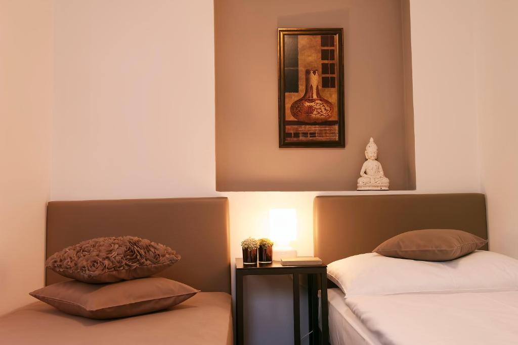 1 dormitorio con 2 camas y una foto en la pared en Villa na Vinici, en Praga